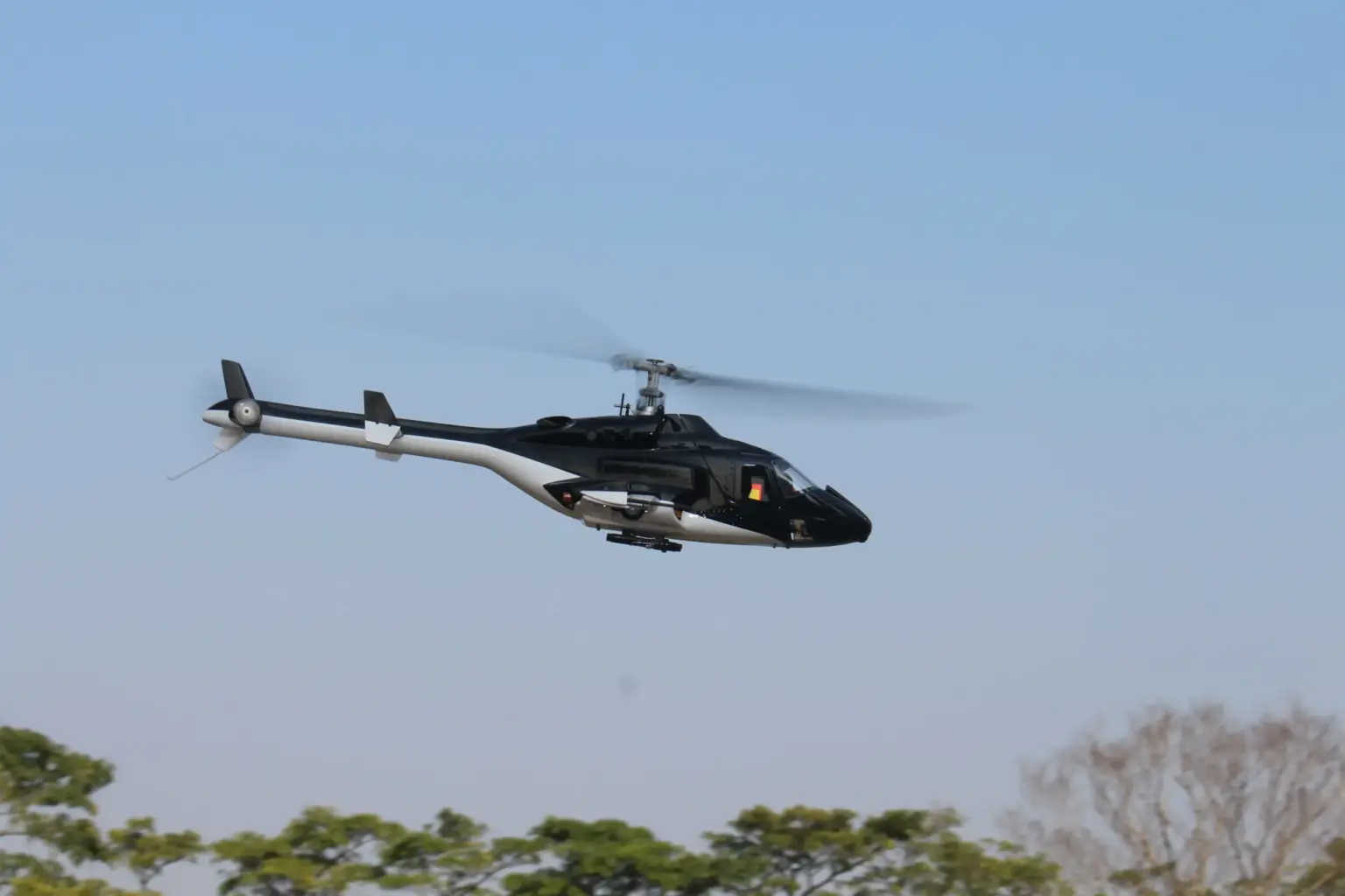 Flish RC Airwolf 450 scale RC helicopter in flight against a blue sky