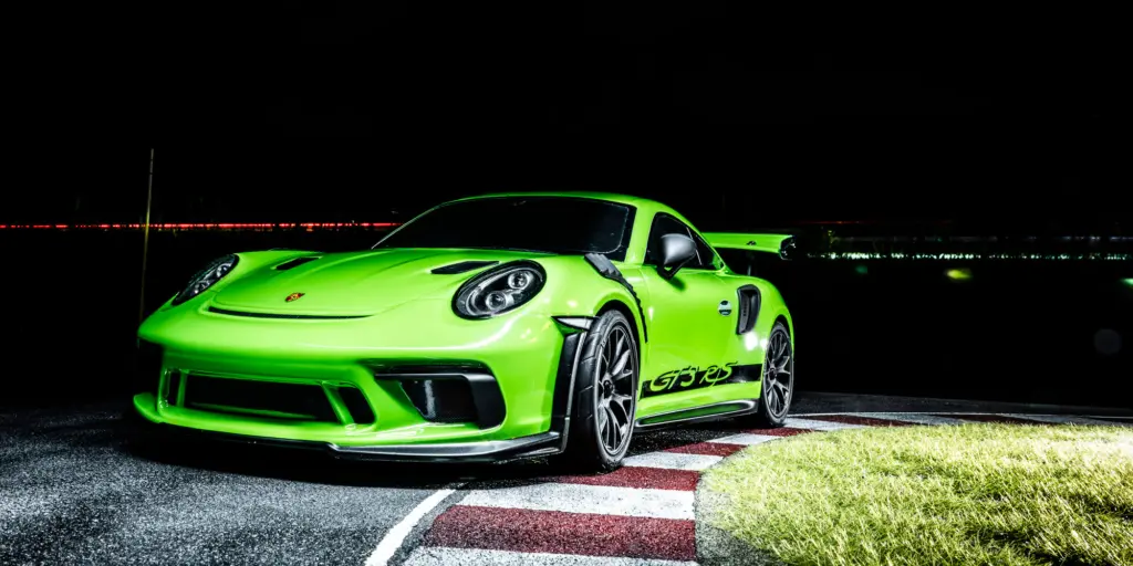 Kyosho Fazer Mk2 Porsche 911 GT3 RS in Lizard Green on a floodlit circuit at night