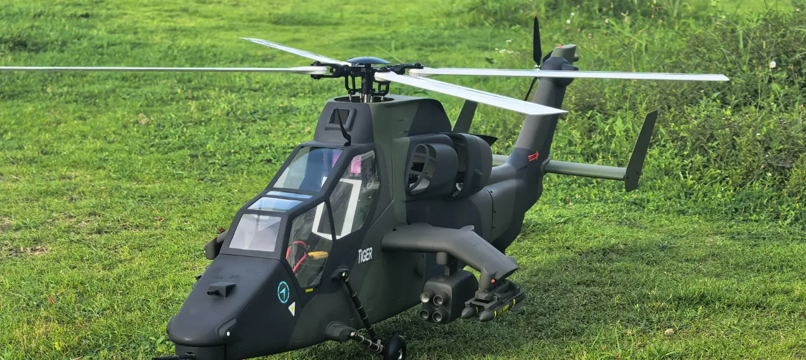 FLISHRC Tiger 700 RC helicopter front three-quarter view showing the four-blade main rotor head and stub wings