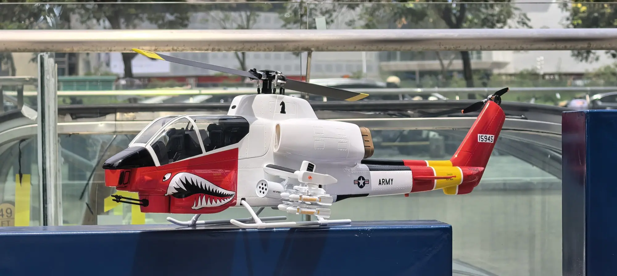 FLISHRC AH-1 Cobra white and red RC helicopter rear quarter view on a display stand