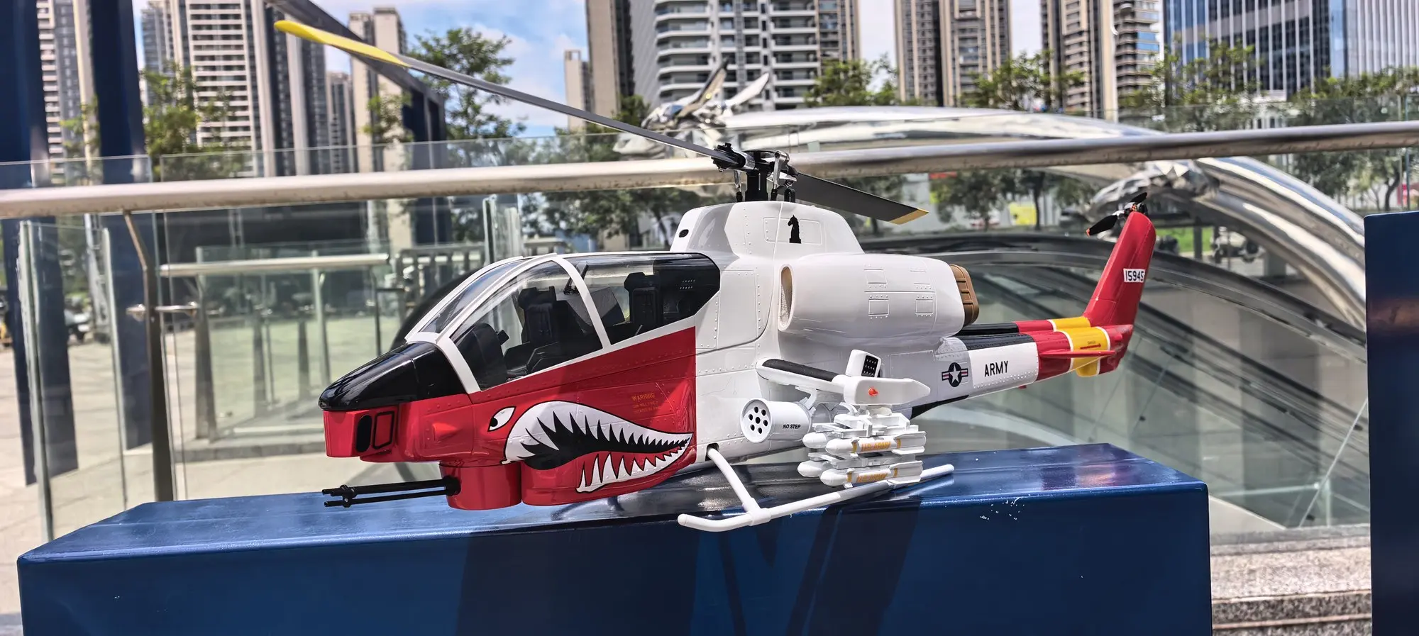 FLISHRC AH-1 Cobra white and red scale RC helicopter displayed on a stand