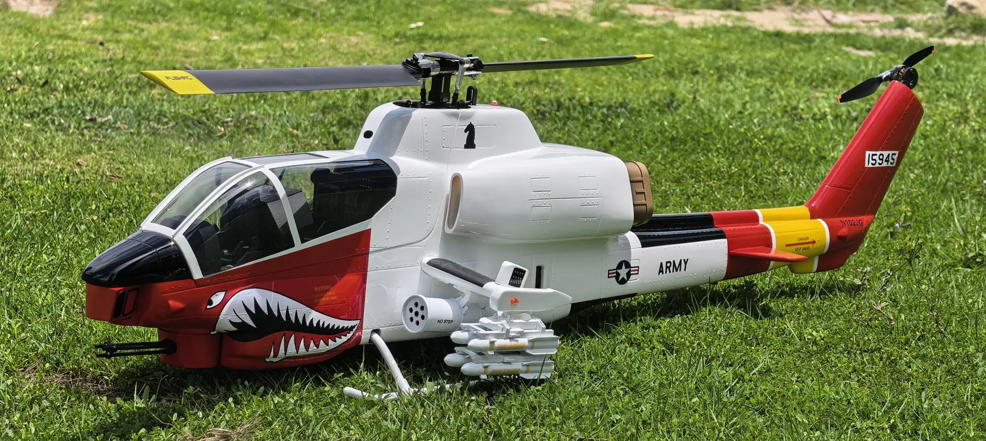 Close-up of the shark-mouth nose art and Armed & Dangerous decal on the FLISHRC AH-1 Cobra white and red scheme