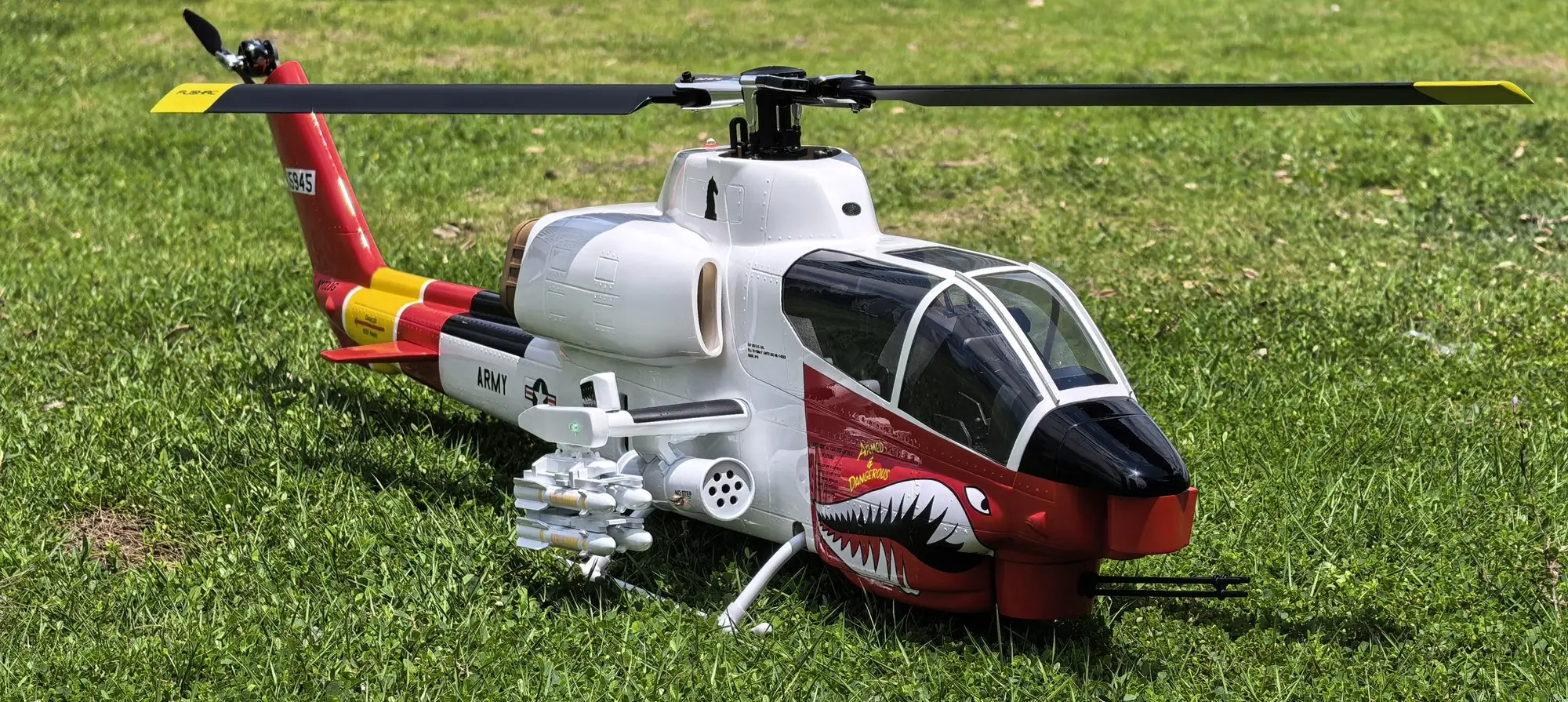 FLISHRC AH-1 Cobra white and red 500-class scale helicopter side-on outdoors on grass