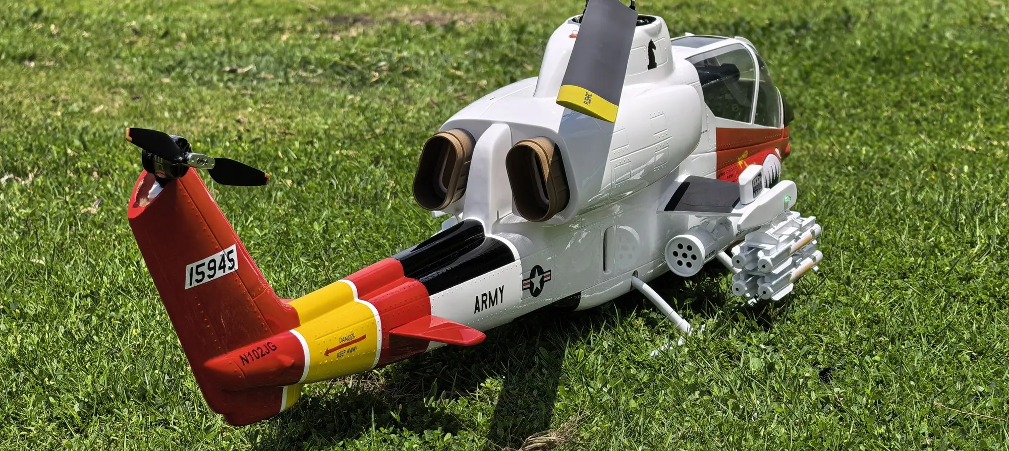 Rear view of the FLISHRC AH-1 Cobra white and red helicopter showing engine deck, exhausts and red tail boom